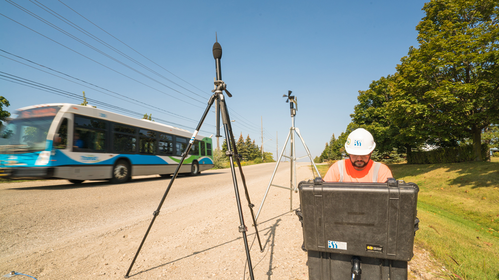 Technician with noise monitoring equipment on roadside