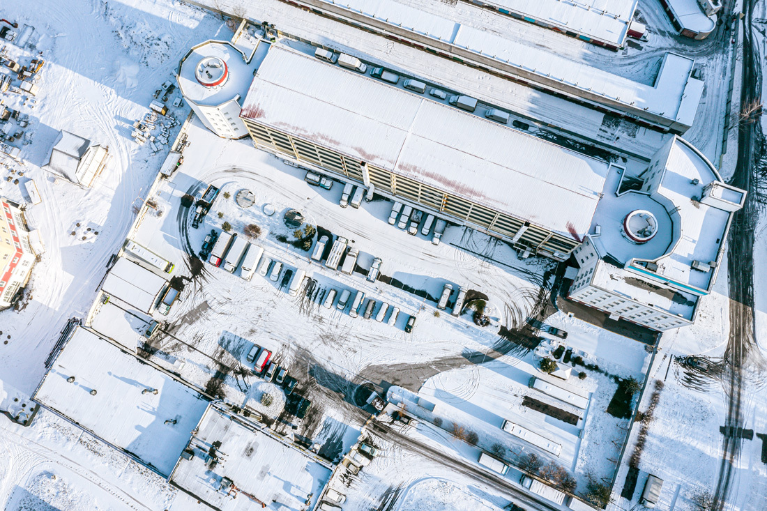 Aerial view of snow covered rooftops and parking lot demonstrates why we need climate change provisions for resilient building design