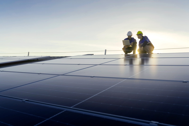 Photo of specialist technician professional engineers with laptop performing maintenance and installation work on solar panels
