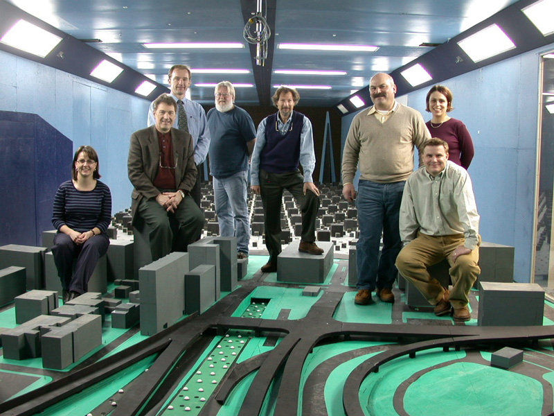Engineering team poses in front of the scale model in a wind tunnel used for the Boston Artery project